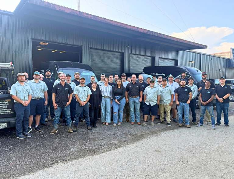 The 409 Group team standing together in front of their service vans